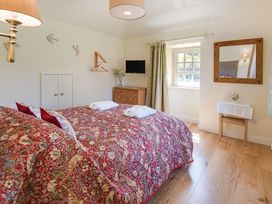 A bedroom with two beds and a television at Country Cottage Sleeps 3 with Garden and Parking