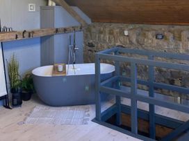 A bathroom with a bathtub and plants at 1-Bed Barn Conversion, Sleeps 2 with Parking Niwbwrch (newborough)