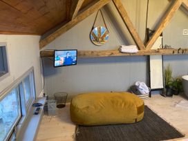 A living room with a television, bean bag, and mirror at 1-Bed Barn Conversion, Sleeps 2 with Parking in Niwbwrch (newborough)