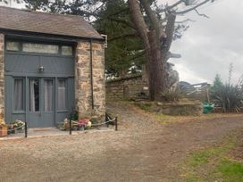 An outdoor view of a stone building with a door and windows at 1-Bed Barn Conversion, Sleeps 2 with Parking, Niwbwrch (newborough)