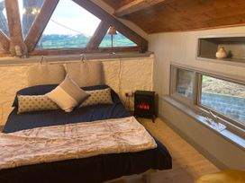 A bedroom with a bed and pillows at 1-Bed Barn Conversion, Sleeps 2 with Parking, Niwbwrch (newborough)