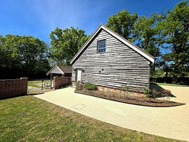 A building with a gate and pathway at Charming Barn Annex with Stables New Forest Escape
