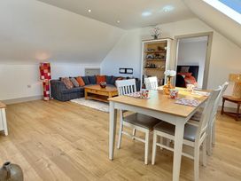A living room with a sofa and dining area at Charming Barn Annex with Stables New Forest Escape