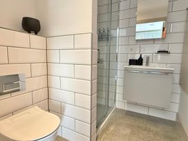 A bathroom with a toilet, shower, and sink at Charming Barn Annex with Stables New Forest Escape