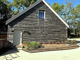 A wooden building with a door and window in the garden at Charming Barn Annex with Stables New Forest Escape