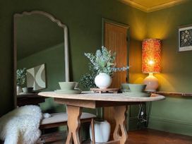 A dining room with a round table and a mirror at Llysawelon 2-Bed Cottage, Sleeps 5, Pets Ok Llysawelon near Llansteffan