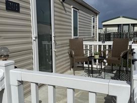 An outdoor patio with two chairs and a table at 2-Bed Caravan, Sleeps 6 w/ Parking, No Pass Needed