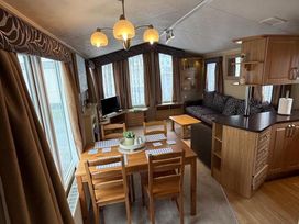 A living room with a dining table and sofa at 2-Bed Caravan, Sleeps 6 w/ Parking, No Pass Needed