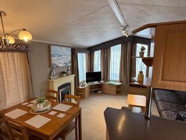 A living room with a dining table and chairs at 2-Bed Caravan, Sleeps 6 w/ Parking, No Pass Needed