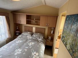 A bedroom with a bed and shelf at 2-Bed Caravan, Sleeps 6 w/ Parking, No Pass Needed