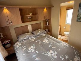 A bedroom with a bed and attached bathroom at 2-Bed Caravan, Sleeps 6 w/ Parking, No Pass Needed
