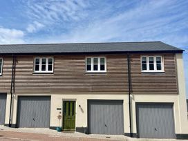 A house with a green door and multiple garage doors at Apartment Sleeps 4 with Parking in Chagford