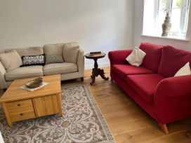 A living room with a red sofa and coffee table at Apartment Sleeps 4 with Parking in Chagford