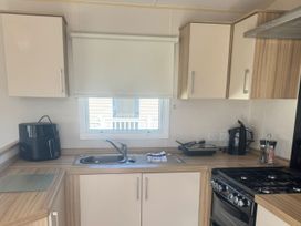 A kitchen with a sink and appliances at Caravan - Sleeps 6 - Parking in Lossiemouth