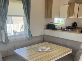 A dining area with a table and chairs at Caravan - Sleeps 6 - Parking Lossiemouth