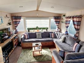 A living room with a sofa and television at D&T Caravan Hire Southview Holiday Park Skegness