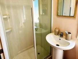 A bathroom with a shower and wash basin at D&T Caravan Hire Southview Holiday Park Skegness