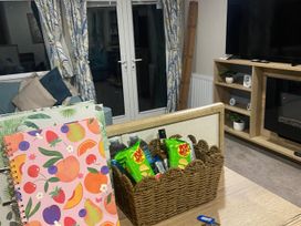 A living room with a table and items on it at Coworth Deluxe Cabin with Garden