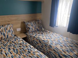 A bedroom with two beds and a window at Coworth Deluxe Cabin with Garden