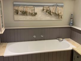 A bathroom with a bathtub and artwork at Cotswolds - Garden - Bbq - Parking - Sleeps 6 near Shipston-On-Stour