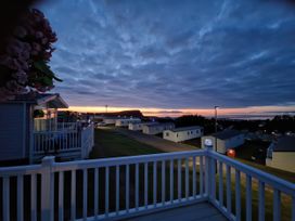 A view from a balcony overlooking houses and the sea at Caravan Sleeps 6 with Sea Views and Parking in Ayr