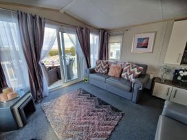 A living room with a sofa and rug at Caravan Sleeps 6 with Sea Views and Parking Ayr