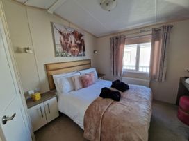 A bedroom with a bed and nightstand at Caravan Sleeps 6 with Sea Views and Parking in Ayr