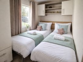 A bedroom with two beds and a window at Caravan Sleeps 6 with Sea Views and Parking Ayr