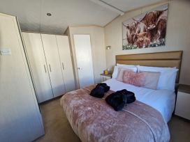 A bedroom with a bed and wardrobe at Caravan Sleeps 6 with Sea Views and Parking in Ayr