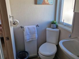 A bathroom with a toilet and a sink at Caravan Sleeps 6 with Sea Views and Parking in Ayr