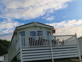 A mobile home with a deck and flowers in Ayr