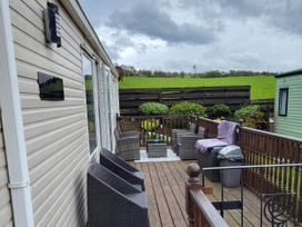 A patio with outdoor furniture and a grill at BandR Turnberry Escape Scotland in Girvan