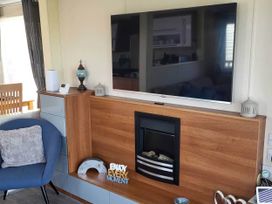 A living room with a television and fireplace at BandR Turnberry Escape Scotland in Girvan