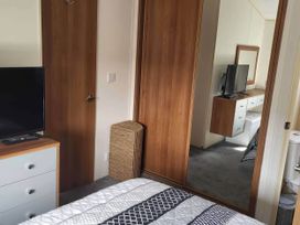 A bedroom with a television and drawers at BandR Turnberry Escape Scotland in Girvan