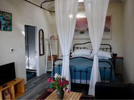 A bedroom with a bed and flowers on a table at Little Linney Sleeps 2 Garden Parking Wifi in Hartland