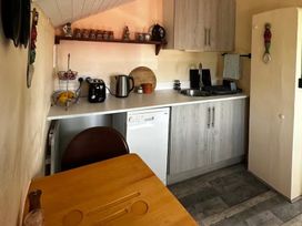 A kitchen with appliances and furniture at Little Linney Sleeps 2 Garden Parking Wifi Hartland