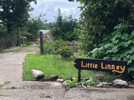 A pathway with a sign pointing to Little Linney in Hartland