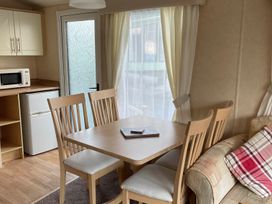 A dining area with a table and chairs at Beautiful 2 Bed Static caravan