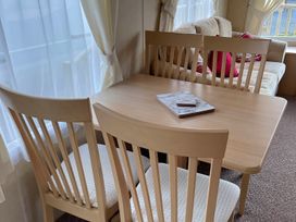 A dining area with a table and chairs at Beautiful 2 Bed Static caravan