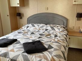 A bedroom with a bed and nightstands at Beautiful 2 Bed Static caravan