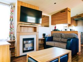 A living room with a television and sofa at Captivating 6-Person Caravan in Rhyl
