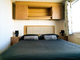 A bedroom with a bed and bedside tables at Captivating 6-Person Caravan in Rhyl