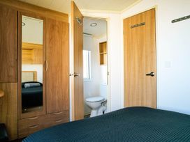 A bedroom with a bed and wardrobe at Captivating 6-Person Caravan in Rhyl