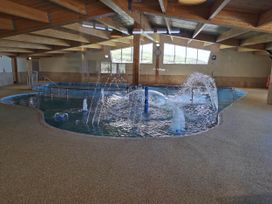 An indoor swimming pool with water fountains at Sea and Mountain view Sunbeach Holiday Snowdonia in Llwyngwril