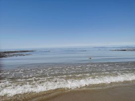 A view of the sea with waves and rocks at Sea and Mountain view Sunbeach Holiday Snowdonia in Llwyngwril