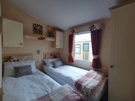 A bedroom with two single beds and a window at Sea and Mountain view Sunbeach Holiday Snowdonia Llwyngwril