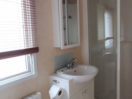 A bathroom with a sink and shower at Sea and Mountain view Sunbeach Holiday Snowdonia, Llwyngwril
