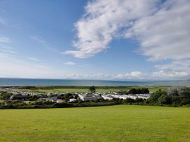 An outdoor view of the sea and green fields at Sea and Mountain view Sunbeach Holiday Snowdonia in Llwyngwril
