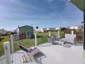 An outdoor area with seating and gas cylinders at Sea and Mountain view Sunbeach Holiday Snowdonia, Llwyngwril