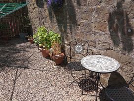 A garden with a table and chair next to potted plants at Ground Floor Cornish Retreat Free Parking Bodmin